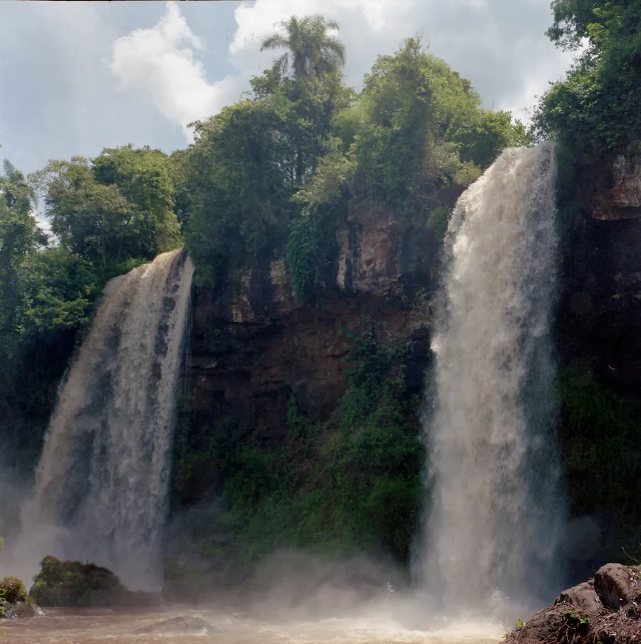 Deux chutes d'eau tombant d'une falaise couverte de végétation tropicale