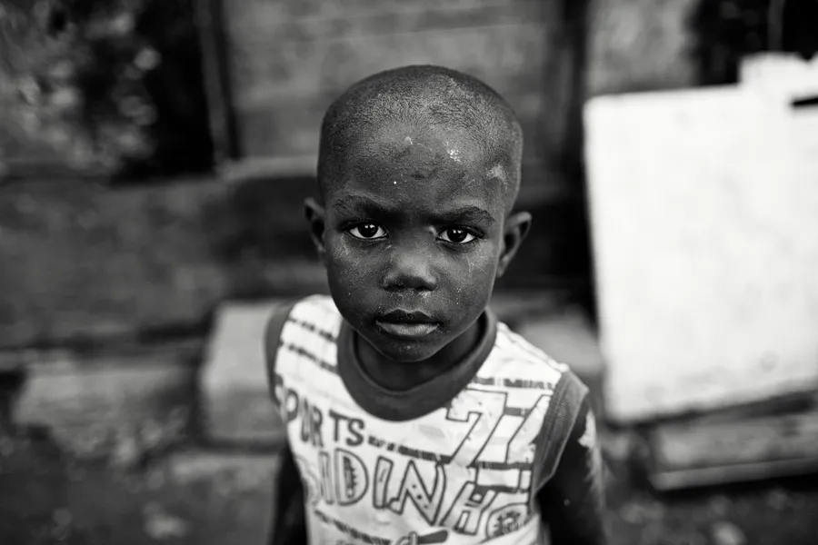 Jeune garçon de face en débardeur imprimé, regard vers l'objectif, vue en plongée, noir et blanc