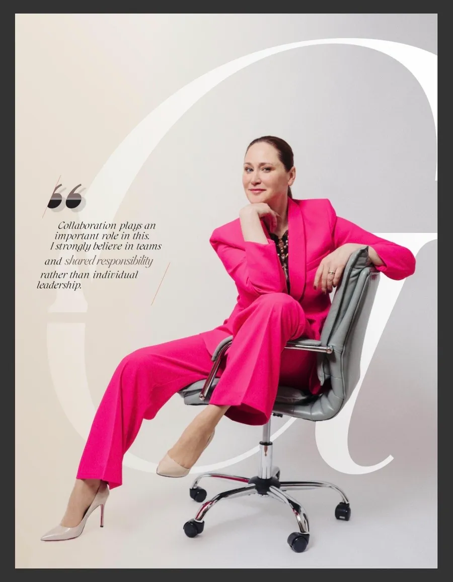 Page de magazine : femme en tailleur rose vif assise sur un fauteuil de bureau, avec citation